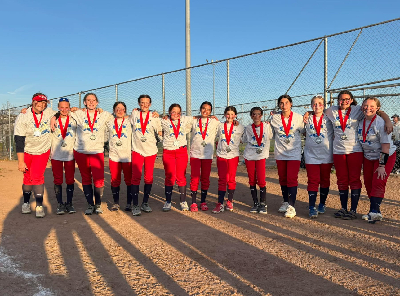 Youth softball team celebrating with medals after game