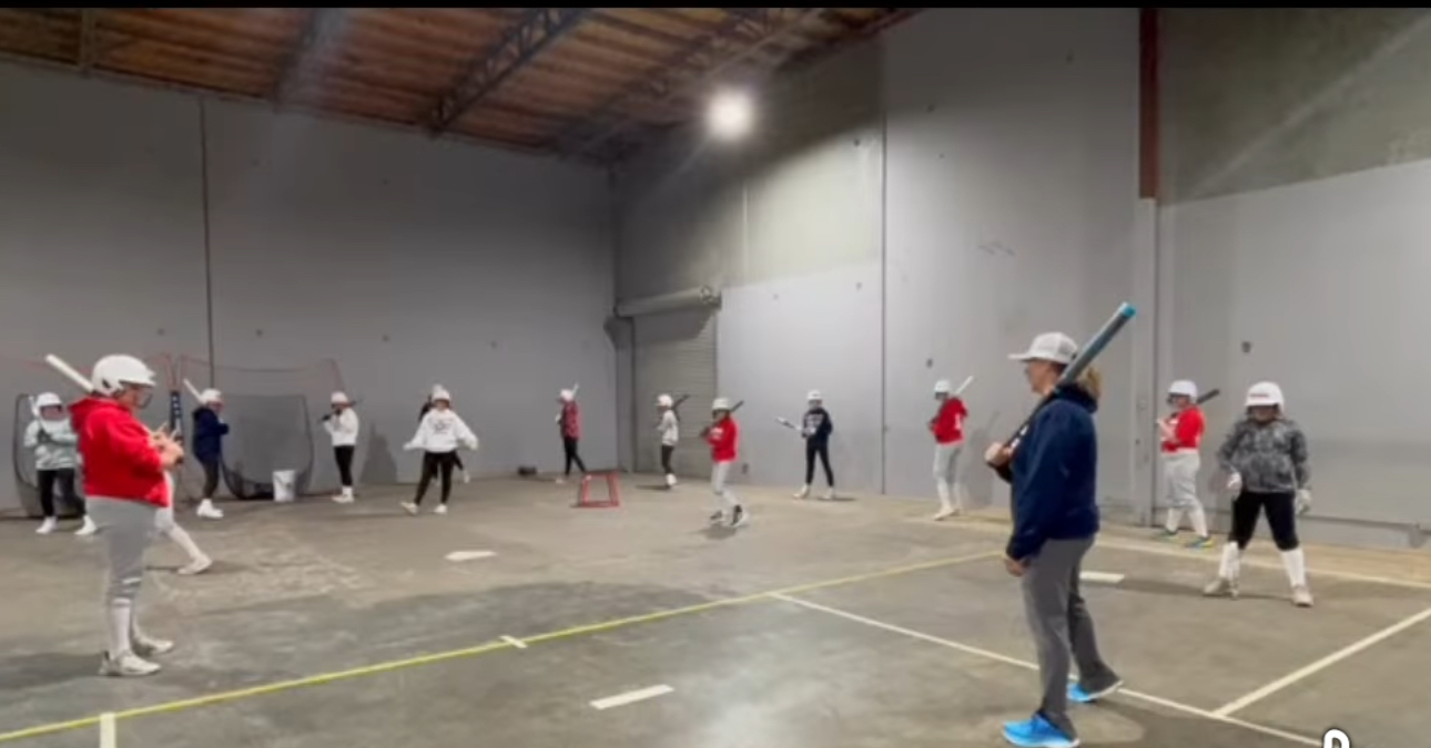 Indoor baseball training session with multiple players